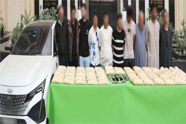 أفراد عصابة جلب الحشيش الاصطناعي وأمامهم المضبوطات
