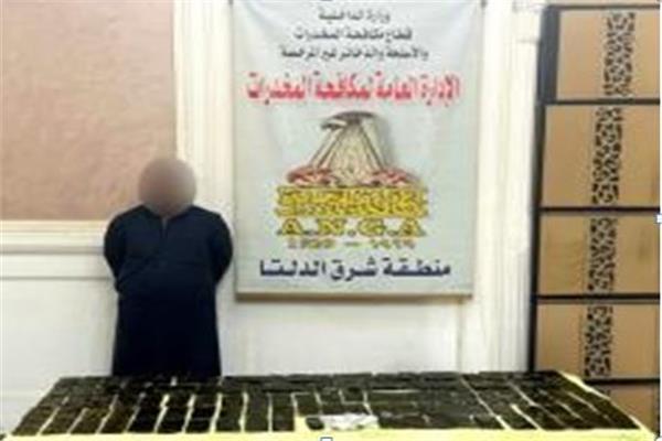المتهم وأمامه المضبوطات