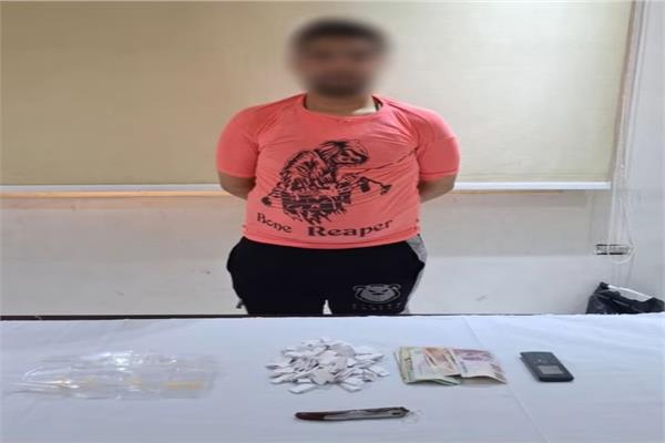 المتهم وامامه المضبوطات