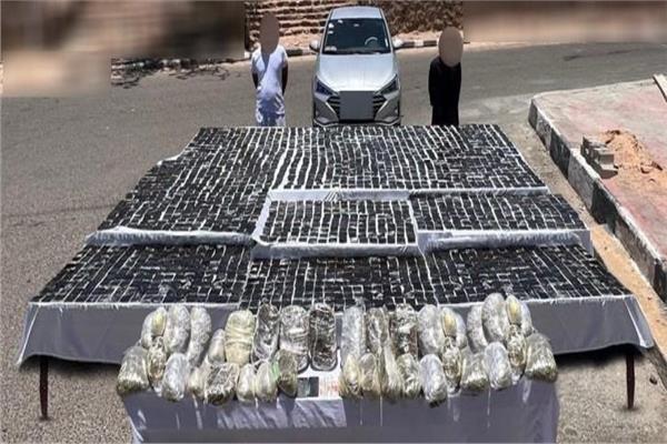 اثنان من المتهمين وأمامهم المضبوطات