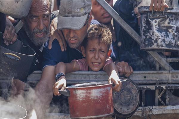 معاناة أهالي غزة خلال حصولهم على لقمة عيش تسد جوعهم - صورة أرشيفية