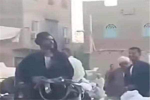 احد المتهمين خلال تجوله بسلاح ناري داخل السوق