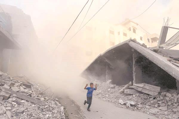 طفل فلسطينى يحاول الفرار من قصف إسرائيلى على غزة       