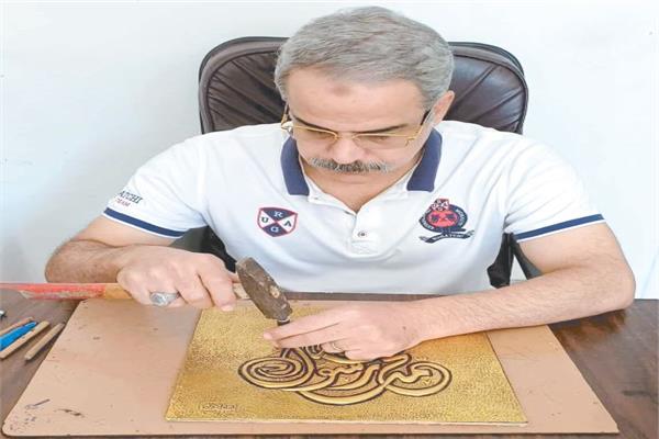 الفنان عمر النجار خلال العمل على إحدى لوحاته