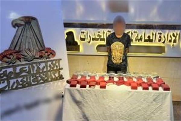 المتهم وأمامه المضبوطات