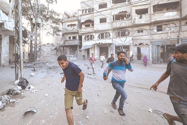 فلسطينيون يهربون من غارة شنها الاحتلال على غزة رغم اتفاق وقف الحرب 