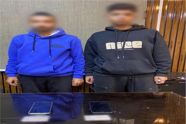 المتهمان وأمامهما المضبوطات