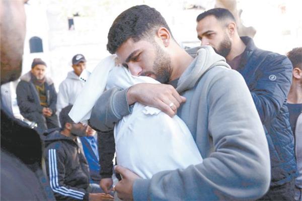 فلسطيني يحتضن أخاه الرضيع للمرة الأخيرة