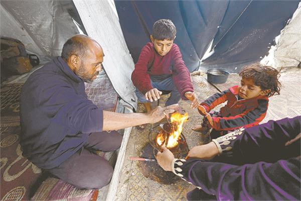 أسرة فى غزة تحتمى من برودة الجو