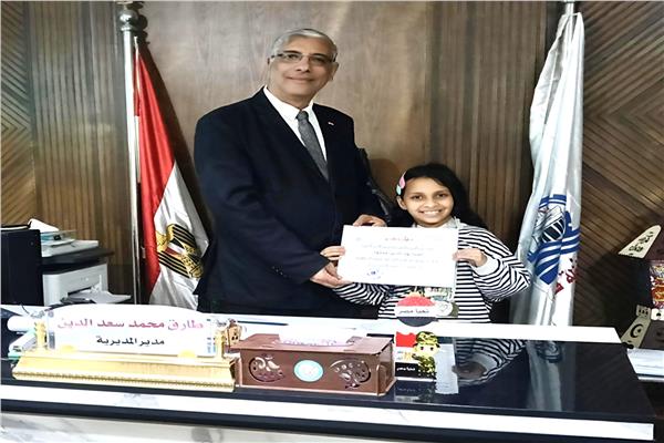 كرم طارق سعد الدين، وكيل وزارة التربية والتعليم بقنا يكرم التلميذة آسيا بهاء الدين