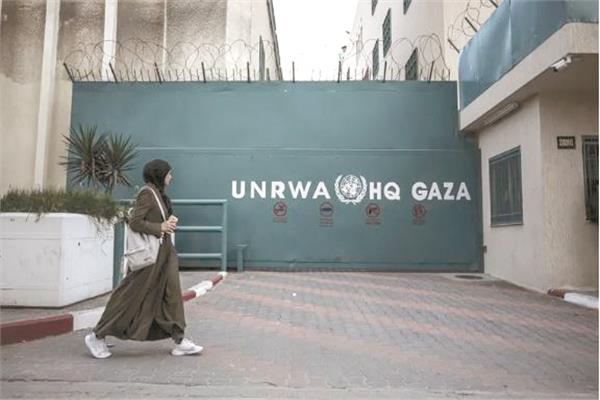 امرأة فلسطينية تسير بجوار أحد المقرات التابعة للوكالة مغلقاً