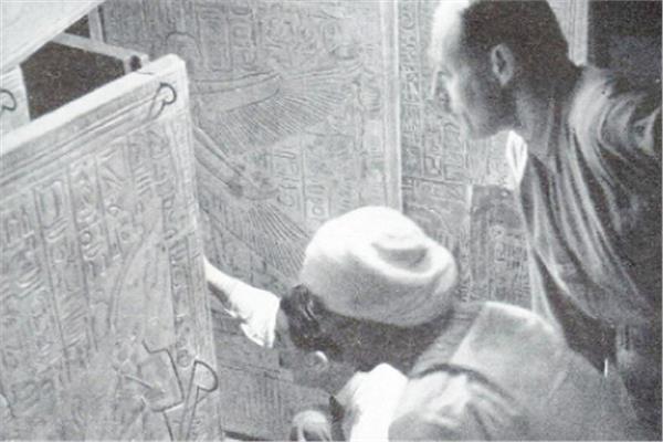 هوارد كارتر وآرثر كالندر وعامل مصرى، ينظرون داخل حجرة الدفن فى مقبرة توت عنخ آمون