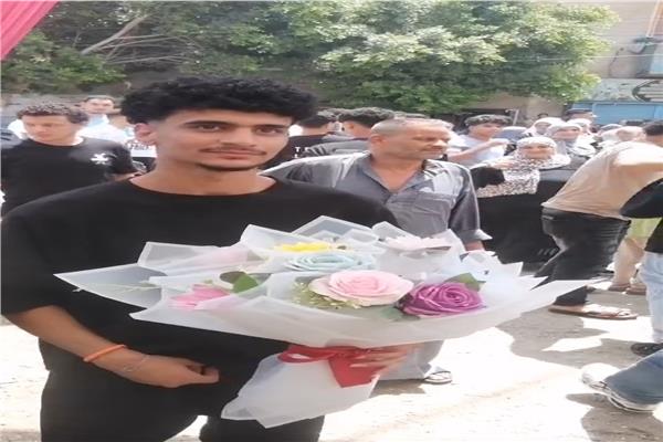 احد طلبة الثانوية العامة يحمل باقة ورد عقب الانتهاء من الامتحانات