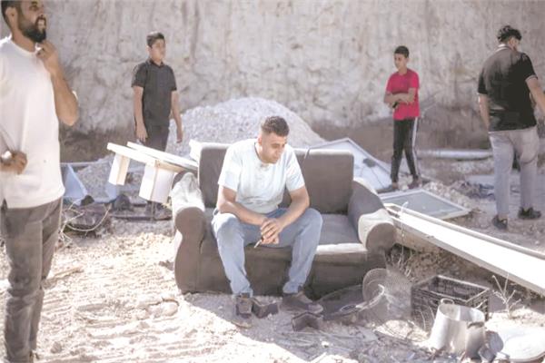 فلسطينى يجلس على أثاث منزله المبعثر فى الضفة