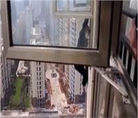 على طريقة افلام الاكشن .. لص صينى يتسلق نافذه الطابق 22 للهروب من الشرطة 