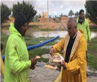 منخفض التنين| صور.. رئيس مدينة برج العرب يوزع الطعام على عمال كسح الأمطار