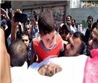 نجل الصحفي الفلسطيني الشهيد فى غزة يلقي نظرة الوداع على جثمان أبيه 