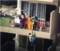 «مشهد مرعب» لأم تدلي طفلها من الطابق التاسع لالتقاط قطعة ملابس| فيديو
