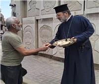 راعي كنيسة بدمياط يوزيع حلوى المولد النبوي على المواطنين 